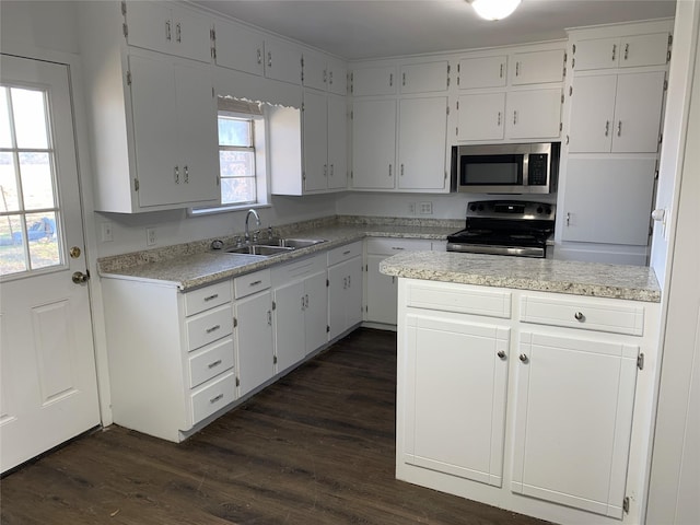 kitchen with appliances with stainless steel finishes, sink, dark wood-type flooring, and white cabinets