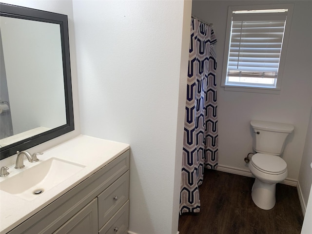 bathroom featuring vanity, wood-type flooring, and toilet