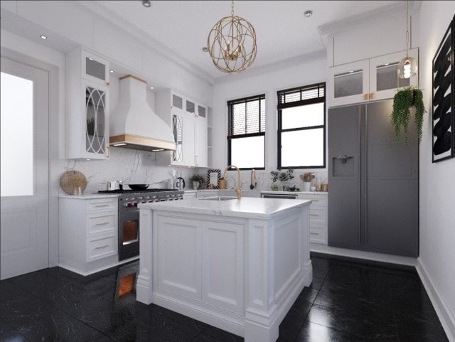 kitchen featuring gas stove, a center island with sink, white cabinets, and custom exhaust hood