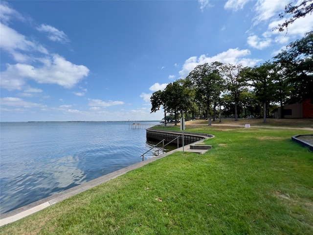 dock area with a water view and a yard