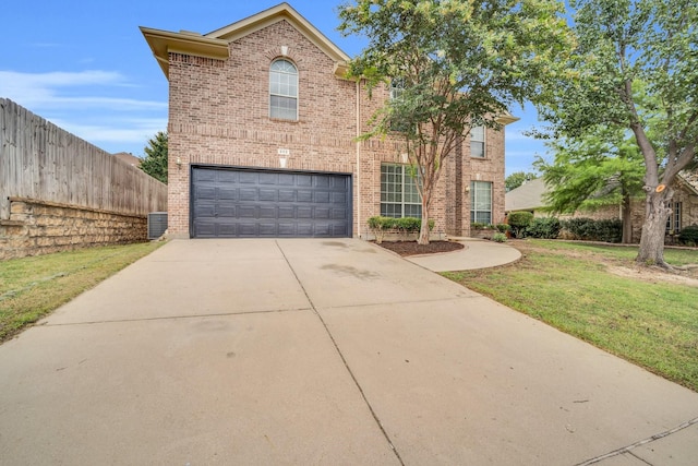 view of front property featuring cooling unit, a garage, and a front lawn