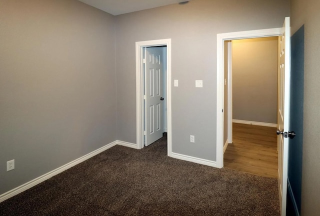 unfurnished bedroom featuring dark carpet