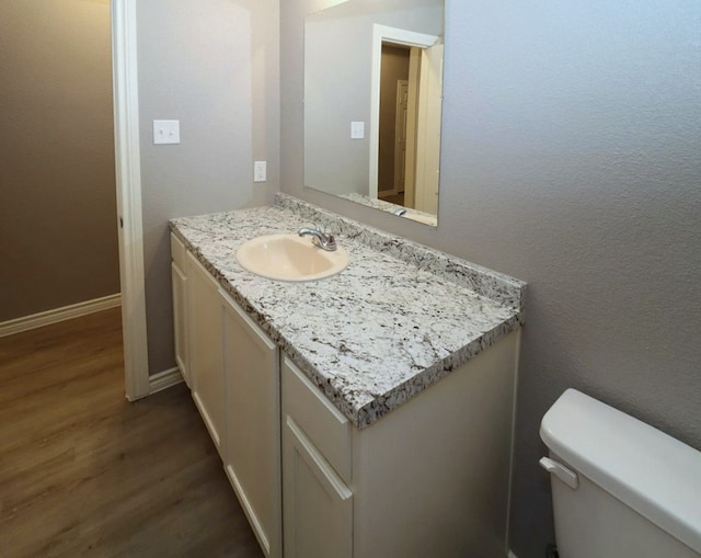 bathroom featuring hardwood / wood-style flooring, vanity, and toilet