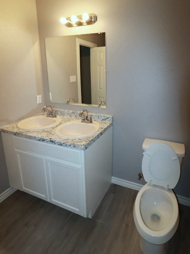 bathroom featuring vanity, hardwood / wood-style flooring, and toilet