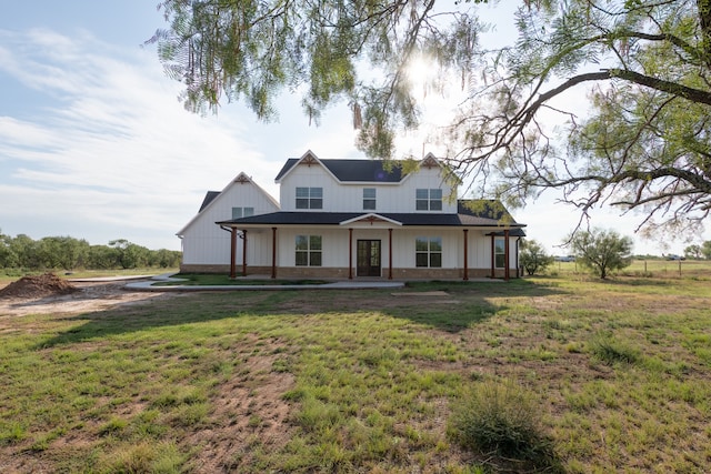 modern inspired farmhouse featuring a front lawn and covered porch