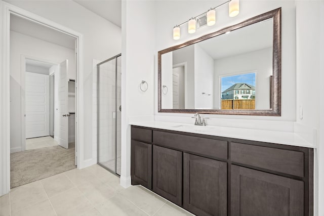 bathroom featuring tile patterned flooring, vanity, and a shower with shower door