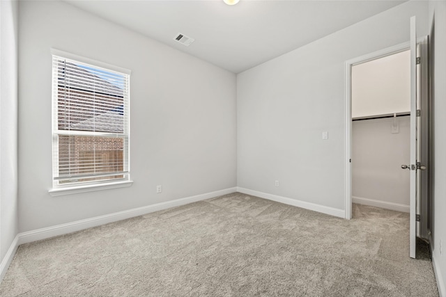 unfurnished bedroom with a closet, light carpet, and multiple windows