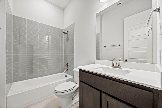 full bathroom featuring tile patterned flooring, vanity, tiled shower / bath combo, and toilet