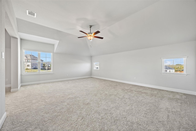 carpeted empty room featuring plenty of natural light, lofted ceiling, and ceiling fan