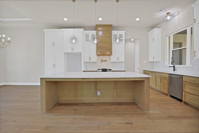 kitchen with light wood-type flooring, white cabinetry, stainless steel dishwasher, and a spacious island