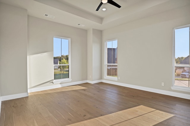 spare room featuring ceiling fan, hardwood / wood-style flooring, and plenty of natural light