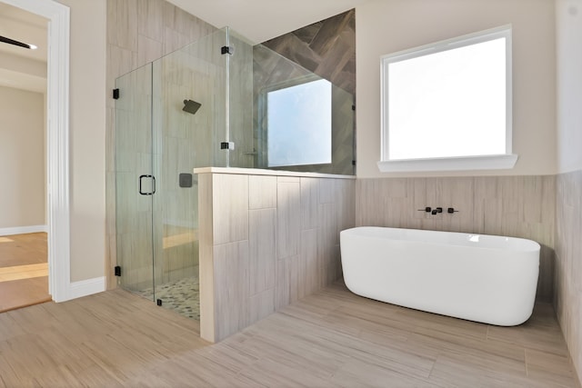 bathroom with wood-type flooring and plus walk in shower