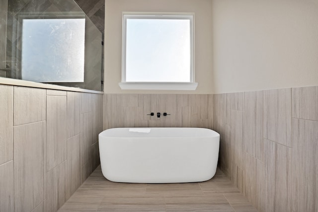 bathroom with tile walls and a washtub