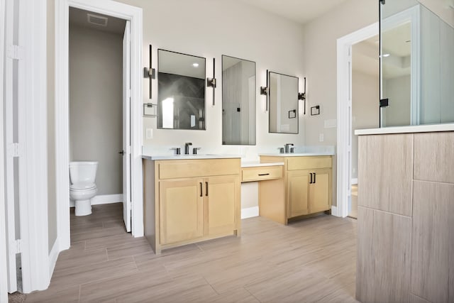 bathroom with hardwood / wood-style flooring, vanity, and toilet