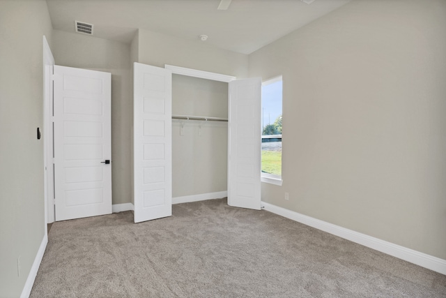 unfurnished bedroom with ceiling fan, a closet, and light carpet