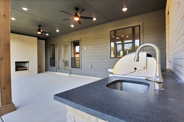 view of patio featuring ceiling fan, sink, and french doors