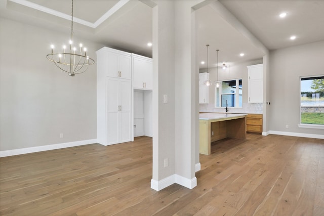 kitchen with light wood-type flooring, tasteful backsplash, hanging light fixtures, a large island, and white cabinetry