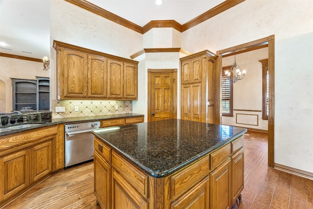 kitchen featuring stainless steel dishwasher, light hardwood / wood-style flooring, a kitchen island, an inviting chandelier, and backsplash