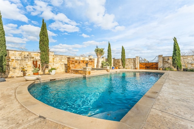 view of pool featuring pool water feature and a patio area