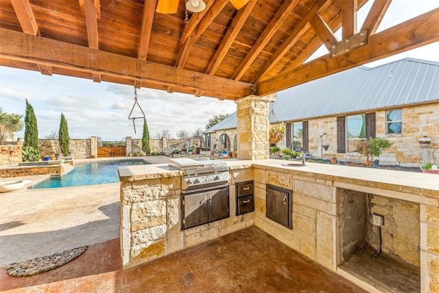 view of patio / terrace featuring sink, exterior kitchen, area for grilling, and a fenced in pool