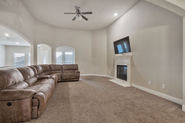 carpeted living room with ceiling fan and a healthy amount of sunlight