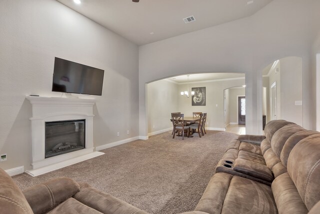 living room featuring carpet, a notable chandelier, and ornamental molding