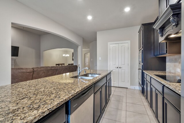 kitchen featuring sink, appliances with stainless steel finishes, light stone countertops, and light tile patterned floors