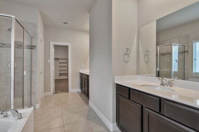 bathroom with tile patterned floors, shower with separate bathtub, and vanity