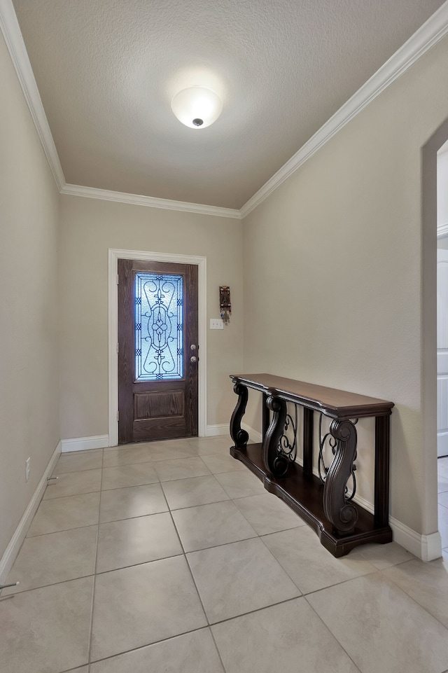 tiled foyer entrance with ornamental molding and a textured ceiling