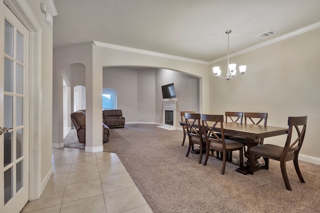 tiled dining room featuring an inviting chandelier and ornamental molding