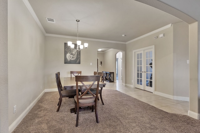 tiled dining room with crown molding, french doors, and a chandelier