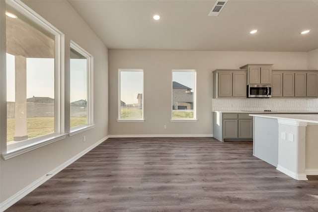 kitchen with dark wood-type flooring, gray cabinets, and decorative backsplash