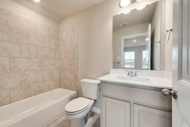 full bathroom featuring tile patterned flooring, toilet, tiled shower / bath combo, and vanity