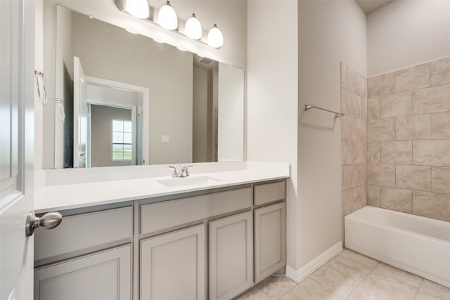 bathroom with tile patterned flooring, vanity, and tiled shower / bath combo