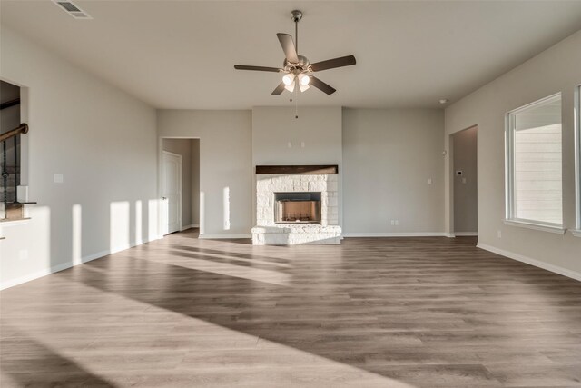 unfurnished living room with hardwood / wood-style floors, ceiling fan, and a fireplace