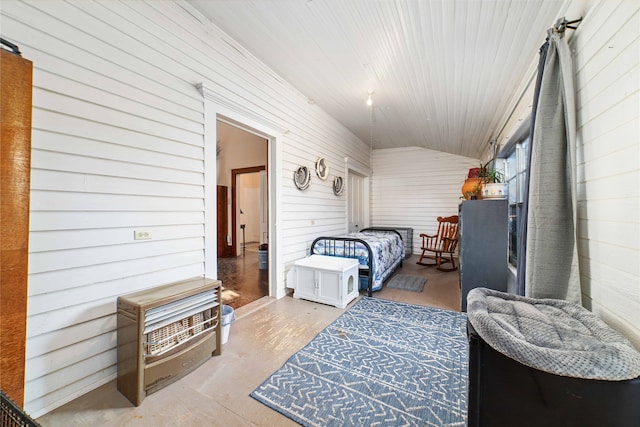 bedroom with wooden walls, lofted ceiling, and concrete floors