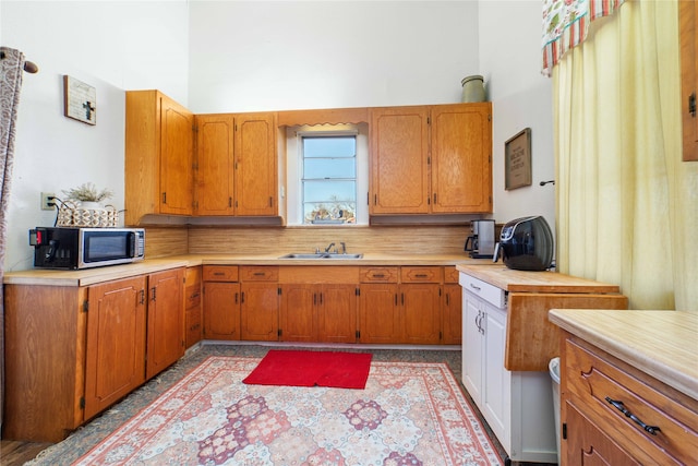 kitchen with backsplash, a high ceiling, and sink