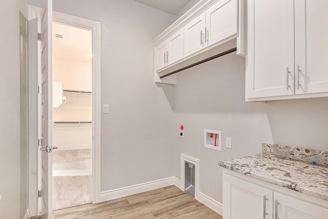 laundry room with hookup for a washing machine, hookup for an electric dryer, and cabinets