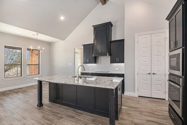 kitchen featuring a breakfast bar, a center island with sink, oven, and built in microwave