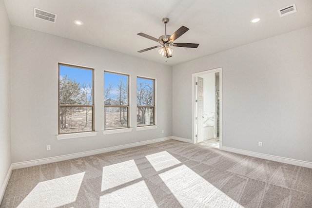 carpeted spare room featuring ceiling fan