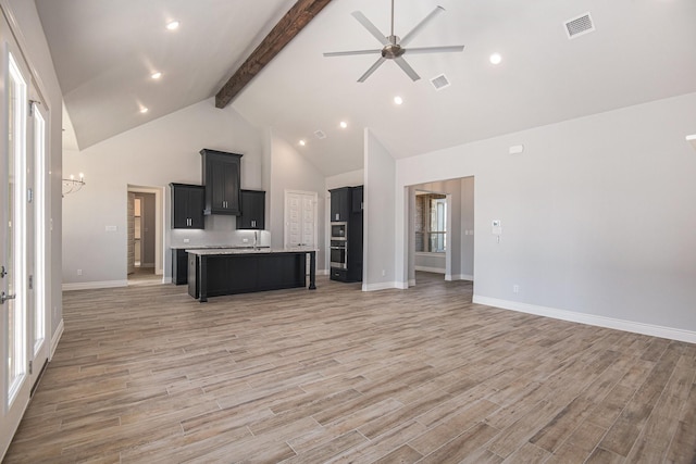 unfurnished living room featuring beam ceiling, high vaulted ceiling, and ceiling fan