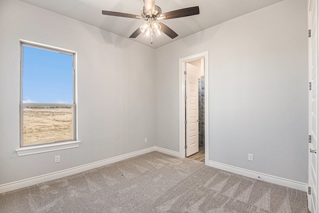 carpeted spare room featuring ceiling fan