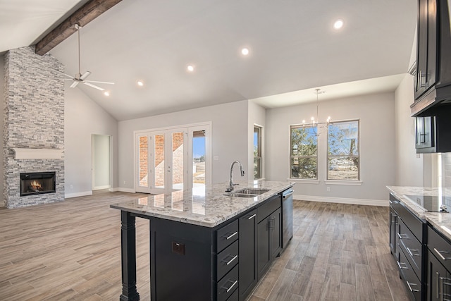 kitchen with a center island with sink, light wood-type flooring, sink, and a wealth of natural light