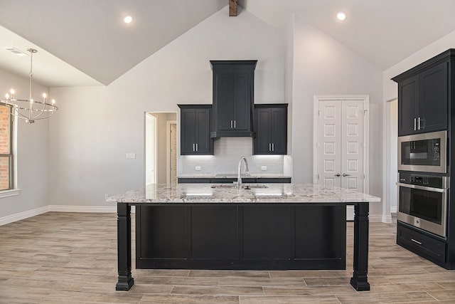 kitchen featuring a kitchen breakfast bar, black microwave, stainless steel oven, and an island with sink