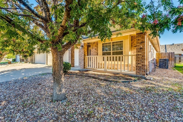 view of front of house featuring a porch, a garage, and central AC unit