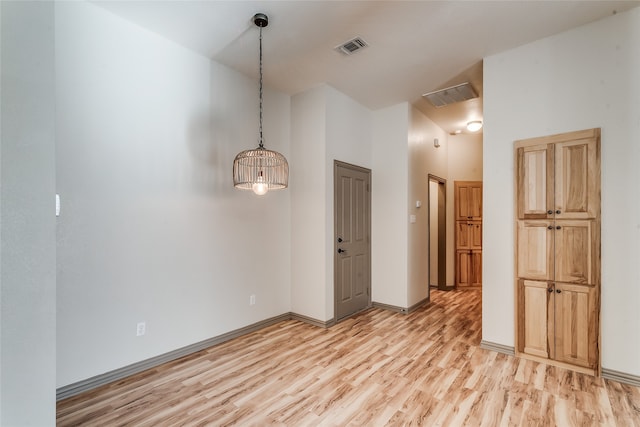 unfurnished room featuring light hardwood / wood-style floors and a towering ceiling