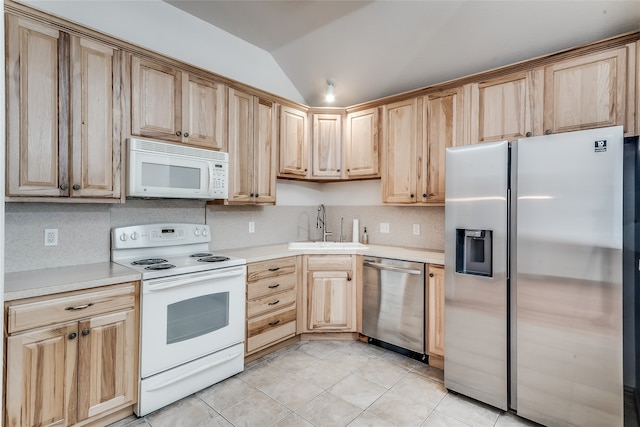 kitchen featuring light brown cabinets, light tile patterned floors, stainless steel appliances, lofted ceiling, and sink