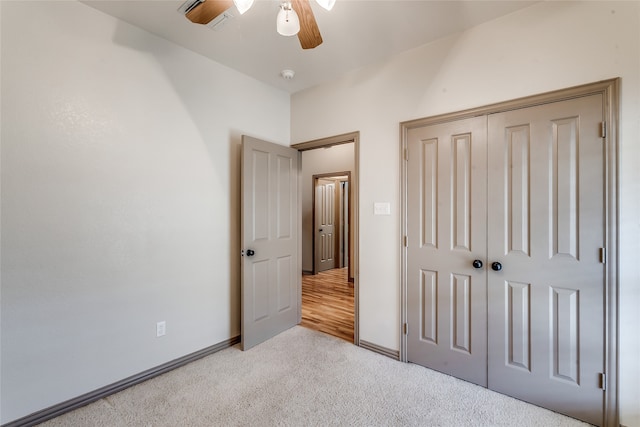 unfurnished bedroom with light carpet, ceiling fan, and a closet