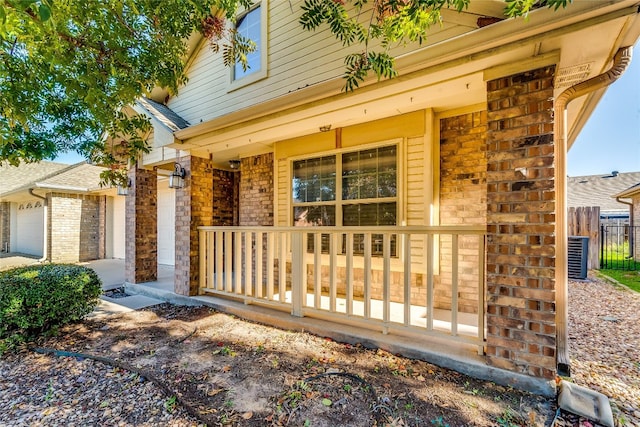 property entrance featuring central AC unit, a garage, and a porch