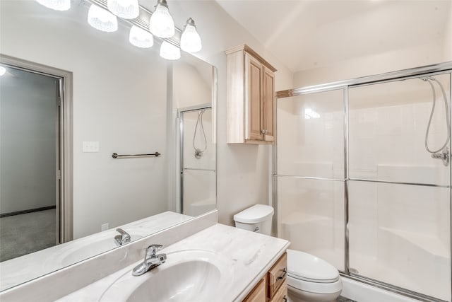 bathroom with vanity, a shower with shower door, and toilet